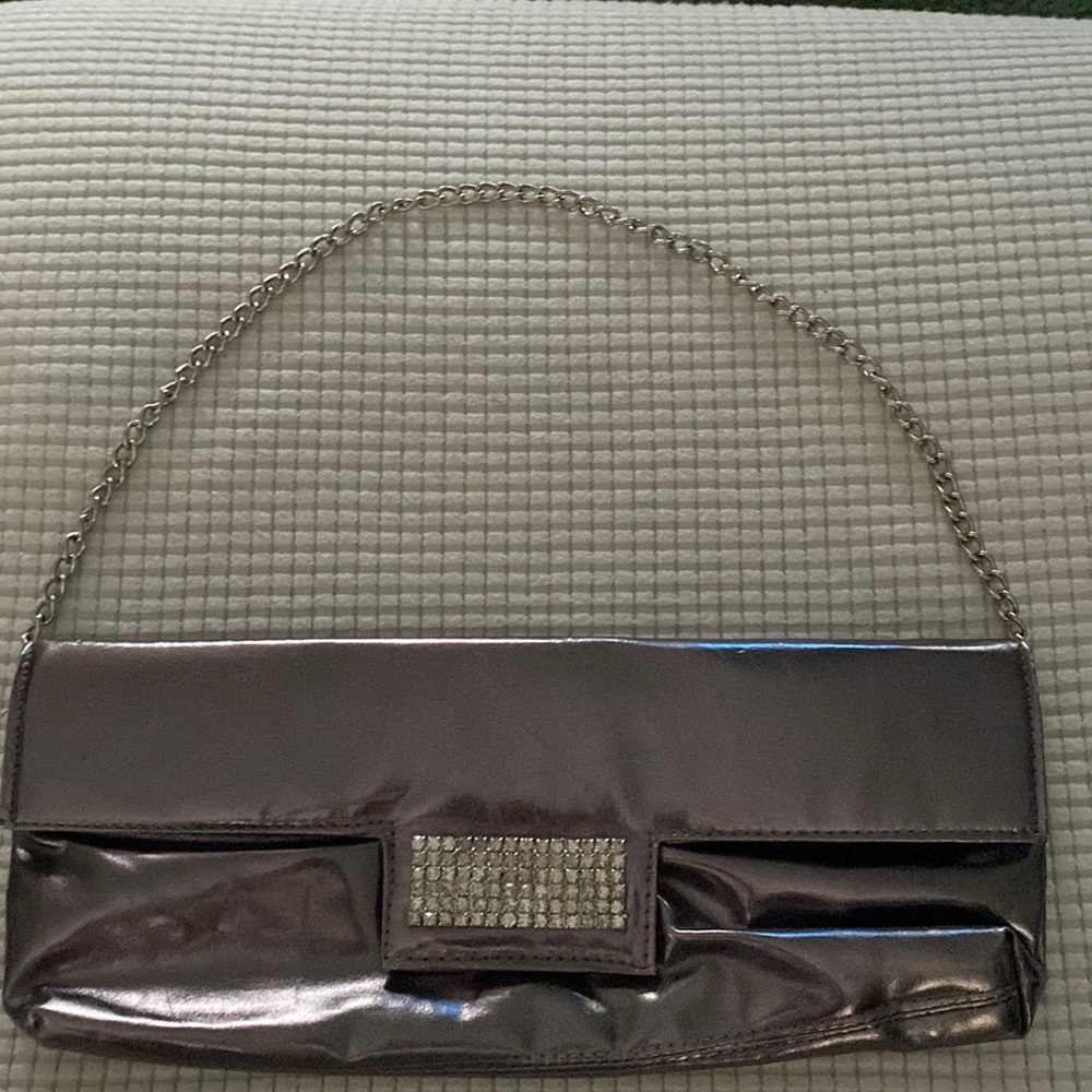 Beautiful clutch purse leather with a square diamond in the front and a chain.